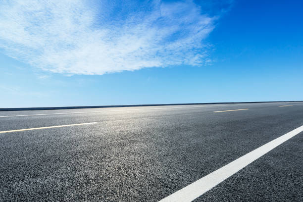 istock Asphalt road ground and blue sky with white clouds scene 1141101269