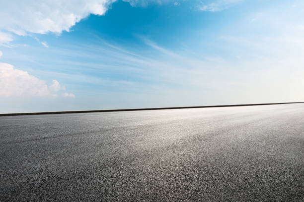 istock Asphalt road ground and blue sky with white clouds scene 1141102461