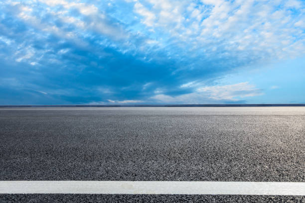 istock Asphalt road ground and blue sky with white clouds scene 1141102494