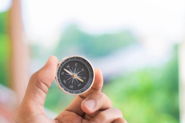 istock man holding compass on blurred background. for activity lifestyle outdoors freedom or travel tourism and inspiration backpacker alone tourist travel or navigator image. 1141102495