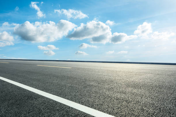 istock Asphalt road ground and blue sky with white clouds scene 1141103853