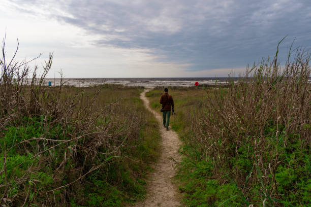 istock Nature Photographer In Action Walking  Down A Grassy Trail  Dres 1141104029