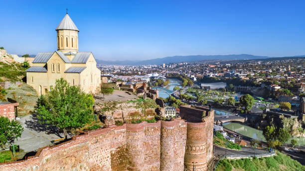 opinião aérea do zangão da skyline de tbilisi de acima, da fortaleza de narikala e da cidade velha da arquitectura da cidade de tbilisi, geórgia - kura river - fotografias e filmes do acervo