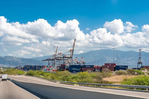 Saint Catherine, Jamaica - March 19 2019: Cargo shipping containers and container cranes at the Port of Kingston, Jamaica's shipping and maritime logistics hub.