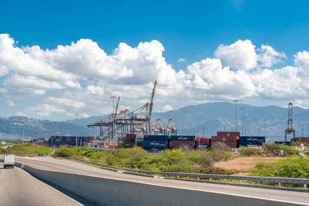 Cargo shipping containers and container cranes at the Port of Kingston, Jamaica Saint Catherine, Jamaica - March 19 2019: Cargo shipping containers and container cranes at the Port of Kingston, Jamaica's shipping and maritime logistics hub. kingston harbour stock pictures, royalty-free photos & images