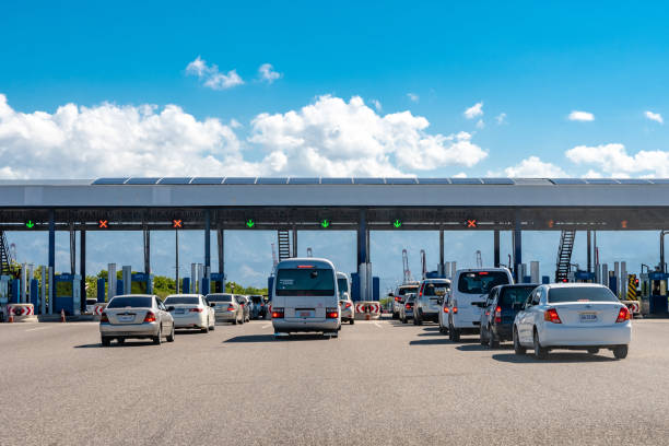 Lanes of cars in traffic at the Portmore Toll Plaza in Jamaica Portmore, Jamaica - March 19 2019: Lanes of cars in traffic at the Portmore Toll Plaza on the Causeway/Highway to Kingston cash in transit vehicle stock pictures, royalty-free photos & images