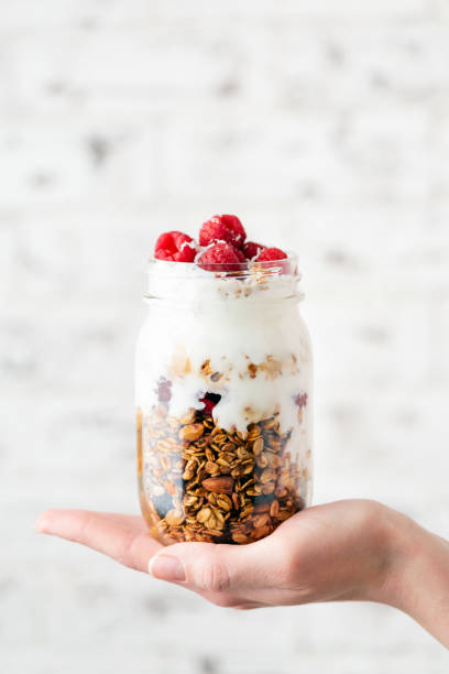 granola e yogurt com as bagas no frasco - jar oatmeal granola glass - fotografias e filmes do acervo