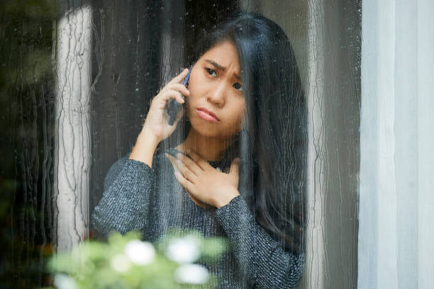 Sympathetic sad young woman having emotional phone call