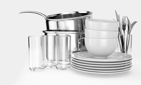An assortment of stacked clean dishes consisiting of plates; glasses; pots and cutlery on an isolated white background - 3D render