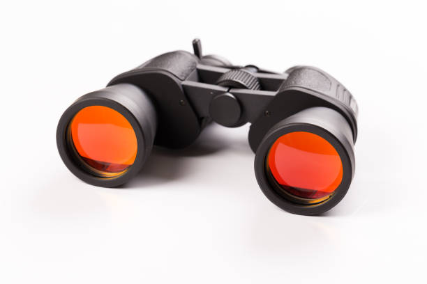 istock Black binoculars with orange lens isolated on white background 1141142492