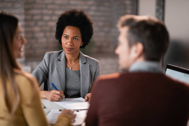 istock Black female insurance agent taking notes while communicating with a couple during a meeting. 1141146060