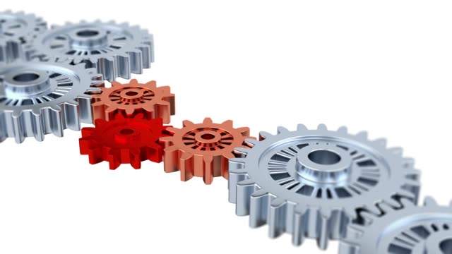 Blurred Silver Gears with One Red Turning in the middle