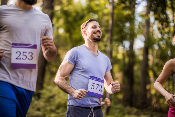 istock Young happy athlete running a marathon in the forest. 1141147644