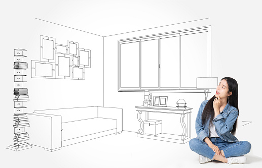 Young  asian business  woman thinking isolated on white background.Dreaming about new house. Thoughtful young woman looking at the sketch on the wall while