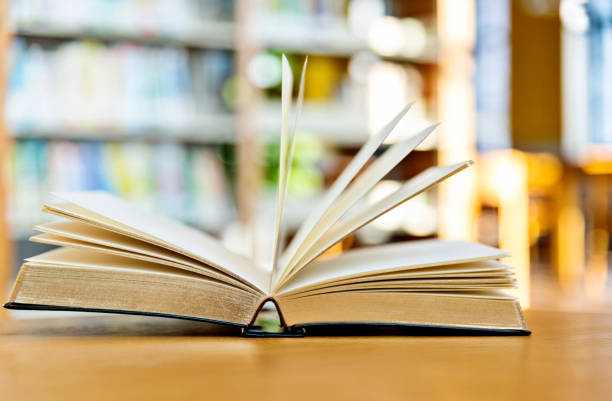 istock An open book on the table of public library 1141148519
