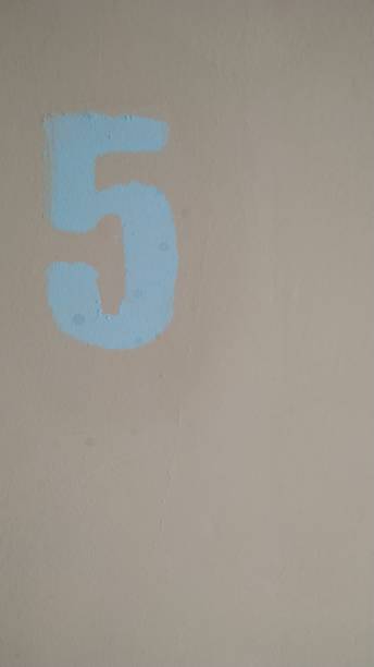 istock Digit 5 painted in blue on a pink background. Close-up. 1141149701