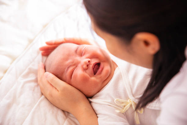 istock Mother holding her crying baby 1141149732