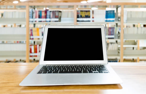 istock Laptop with blank screen in the table of public library 1141149883