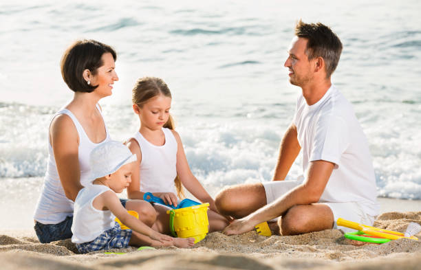 istock Parents with two kids playing with toys on beach 1141150017