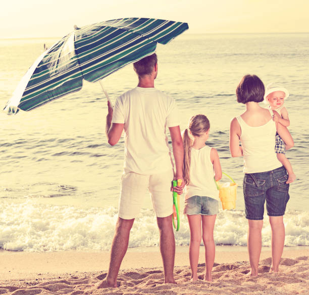 istock Young family of four standing with back forward 1141150018