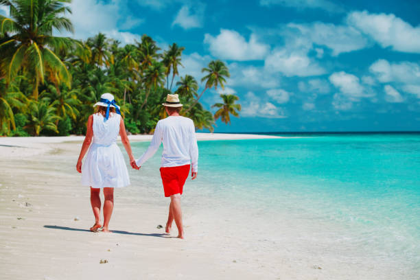 istock happy loving couple walk on beach, vacation concept 1141153160