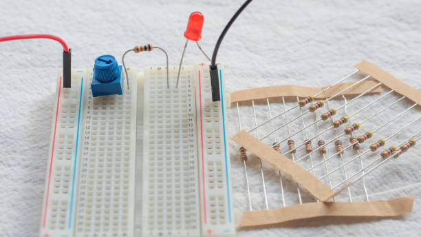 istock Potentiometer, resistors and red LED set up on a breadboard 1141153994