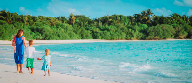 istock mother with three kids walk on beach vacation 1141154147