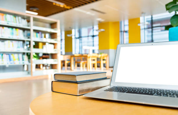 istock Laptop and books on the table of public library 1141154933