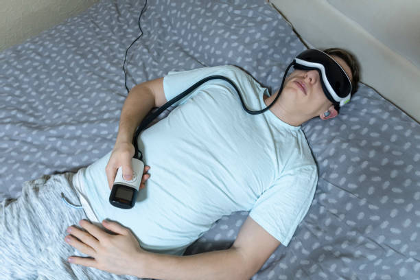 istock young attractive man uses an eye massager device, lying on the bed, holding a remote control 1141155508