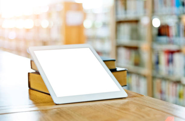 istock Digital tablet and books on the table of public library 1141156067