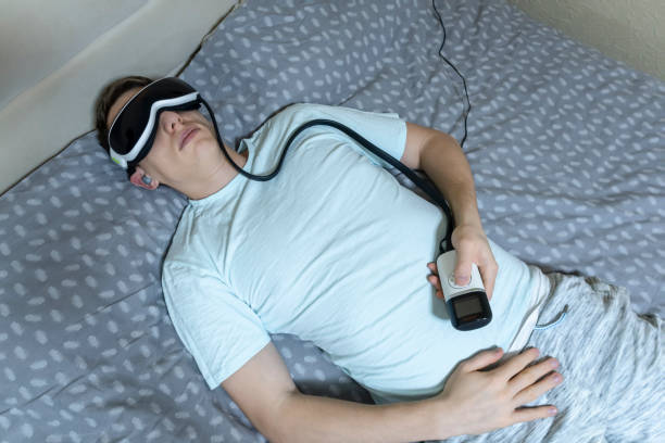 istock young attractive man uses an eye massager device, lying on the bed, holding a remote control 1141156136