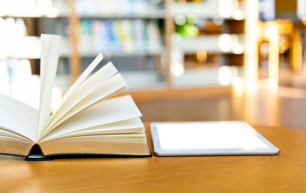 istock Digital tablet and books on the table of public library 1141156323