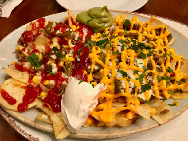 istock Nachos Chips with Melted Cheddar Cheese and Dips Variety 1141156608
