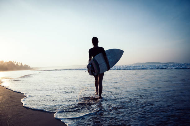 istock Woman surfer with surfboard ready to surf on a beach 1141157590
