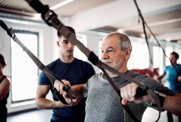 istock A group of seniors in gym with a young trainer doing exercise with TRX. 1141158004