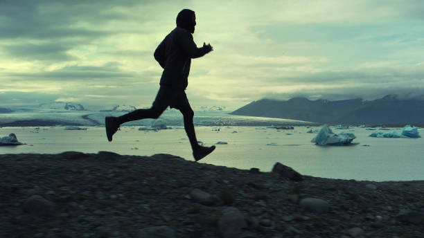 istock Man running along glacier lagoon 1141159457