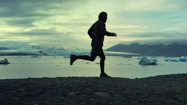 istock Man running along glacier lagoon 1141159476