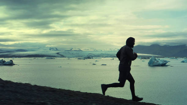 istock Man running along glacier lagoon 1141159491