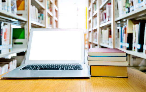 istock Blank laptop and books on the table of library 1141162744