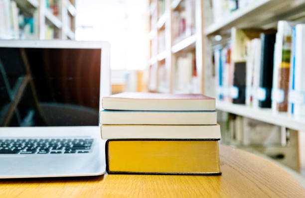 istock Blank laptop and books on the table of library 1141163092