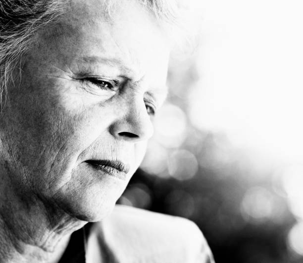 istock Senior woman looks down, seeming anxious and unhappy 1141167433