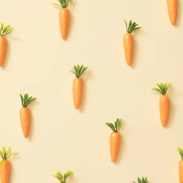 Photo of Carrots on pastel yellow background.