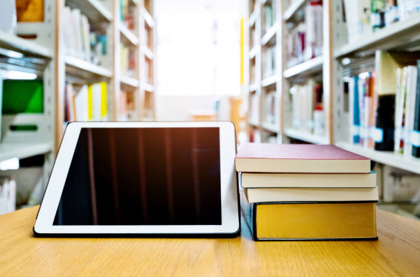 istock Digital tablet and books on wooden table 1141168387