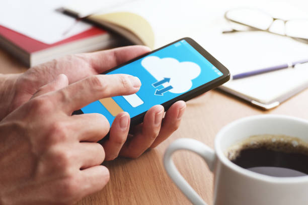istock Closeup of male hands touching smartphone screen for using cloud app at table. 1141169583