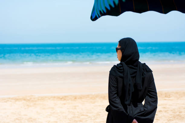 istock Muslim woman on the beach back view 1141173846