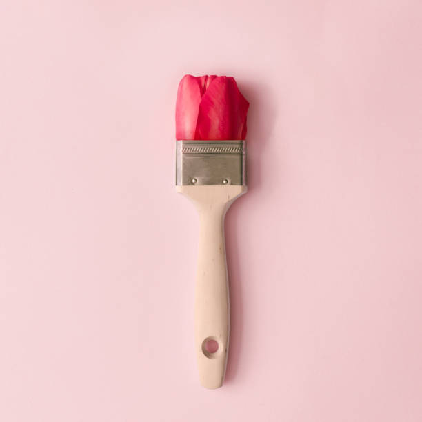 istock Creative spring concept made with paint brush and red tulip flower on pastel pink background. 1141175588