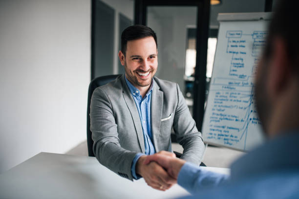 istock Smiling businessmen handshaking over the office desk after effective negotiation. 1141178992