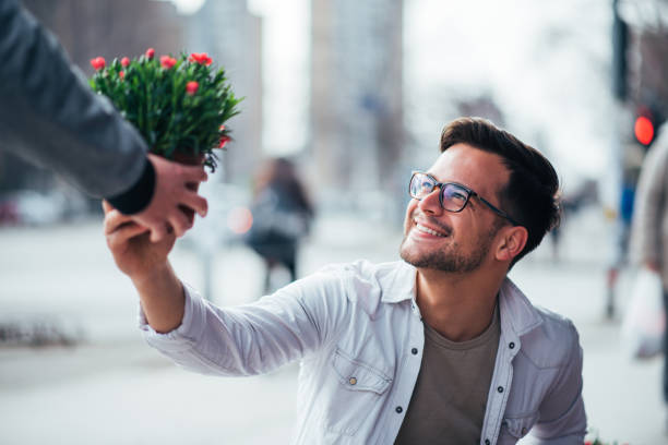 istock Young man selling flowers to a customer, close-up. 1141180068