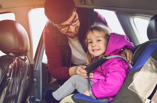 istock Safety first, father puts child in car seat 1141181165