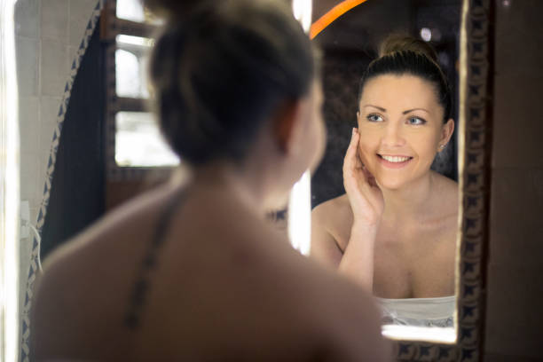 istock Young woman looking in the mirror 1141182522